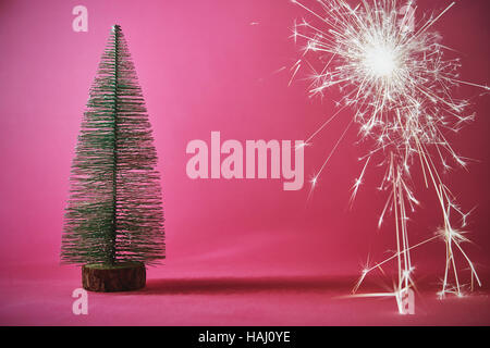 Arbre de Noël sur fond rose avec sparkler Banque D'Images