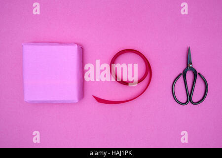 Fort cadeau, ruban et cisailles antiques sur fond rose Banque D'Images