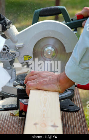 Carpenter planche en bois de coupe avec scie circulaire Banque D'Images