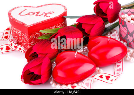 Coeur rouge des bougies, des tulipes, des colliers et des coffrets cadeaux sur fond blanc. Banque D'Images