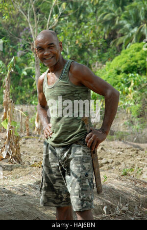 Un agriculteur avec son cleaver dans ses rizières, Lawigan, San Joaquin, Iloilo, Philippines. Banque D'Images