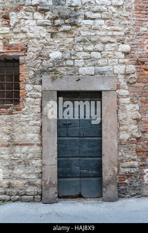 Dans l'Italie ancienne portes battues donnent souvent dans des maisons et à la mode. La richesse n'est pas un spectacle extérieur. Porte de ville de Lucques, Lucques, Toscane, Italie Banque D'Images