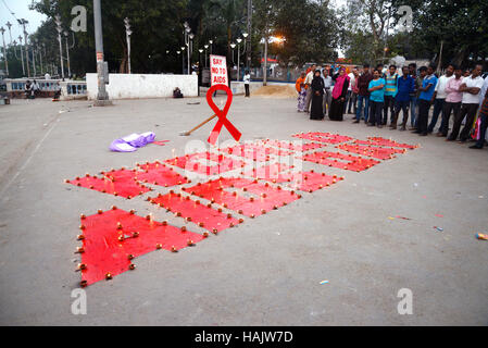 Kolkata, Inde. 06Th Dec 2016. Militant et enfants de dessiner le symbole DE LUTTE CONTRE LE SIDA et les lampes s'allume pendant le programme de la campagne. Dessiner le symbole militant contre le sida et les lumières diya ou aussi lampe lanterne ciel libération pendant une campagne de sensibilisation sur la Journée mondiale de lutte contre le sida sur la banque du fleuve Ganga. La Journée mondiale du sida célébrée chaque année le 01 décembre pour sensibiliser sur le VIH/SIDA et de démontrer la solidarité internationale face à la pandémie. Credit : Saikat Paul/Pacific Press/Alamy Live News Banque D'Images