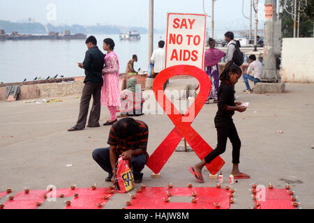 Kolkata, Inde. 06Th Dec 2016. Militant et enfants de dessiner le symbole DE LUTTE CONTRE LE SIDA et les lampes s'allume pendant le programme de la campagne. Dessiner le symbole militant contre le sida et les lumières diya ou aussi lampe lanterne ciel libération pendant une campagne de sensibilisation sur la Journée mondiale de lutte contre le sida sur la banque du fleuve Ganga. La Journée mondiale du sida célébrée chaque année le 01 décembre pour sensibiliser sur le VIH/SIDA et de démontrer la solidarité internationale face à la pandémie. Credit : Saikat Paul/Pacific Press/Alamy Live News Banque D'Images