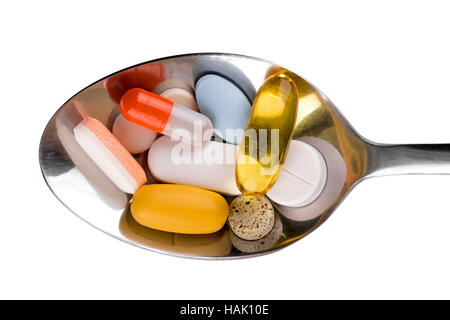 Medical pills in spoon isolated on white Banque D'Images