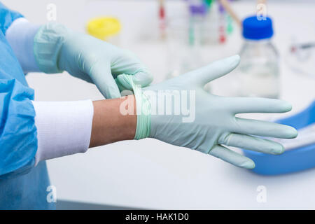 Médecin de mettre des gants chirurgicaux Banque D'Images