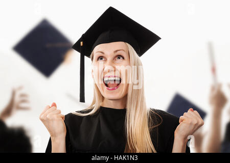 Young happy college graduate wearing cap and gown Banque D'Images