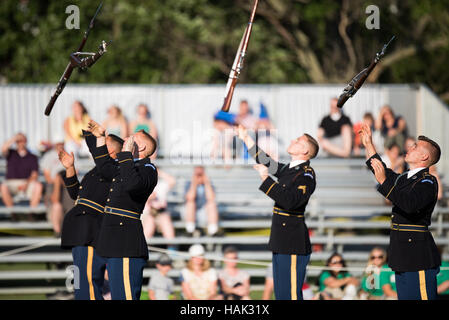 Équipe de maniement du fusil de l'armée américaine Joint Base Myer Henderson Hall Arlington | ARLINGTON, Virginie — Les fusils tourbillonnent dans les airs alors que l'équipe de maniement du fusil de l'armée américaine exécute sa routine signature de lancer-et-rattrapage pendant le Twilight Tattoo à Joint Base Myer-Henderson Hall. Les soldats, membres du 3e régiment d'infanterie des États-Unis (The Old Guard), lâchent des fusils munis de baïonnette au-dessus de leurs têtes dans une manœuvre nécessitant un timing à la seconde près, acquis grâce à un entraînement rigoureux. Le spectacle est donné sur le Summerall Field de Fort Myer. Banque D'Images