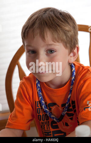 Portrait d'un garçon de 6 ans à la maison portant un self-made tour de cou tressé. Champlin Minnesota MN USA Banque D'Images