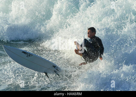 L'homme tombe de Surfboard At Hermosa Beach, Los Angeles, Californie. Banque D'Images