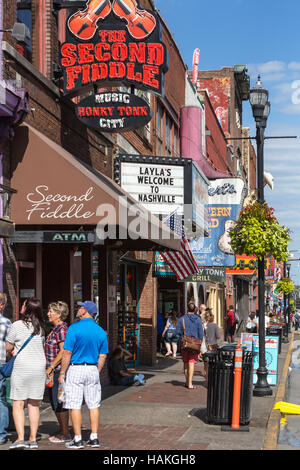Les touristes s'arrêtent en face de l'Honky Tonk bars et magasins sur Broadway inférieur à Nashville, Tennessee. Banque D'Images
