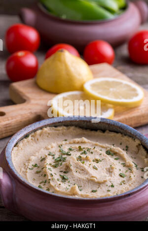 Dans l'Humus bol fait maison avec les légumes autour. Banque D'Images