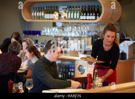 Pizza Express restaurant cuisine italienne serveuse intérieur waiter serving clients heureux chers enfants prenant note pad book Manchester Oxford Banque D'Images