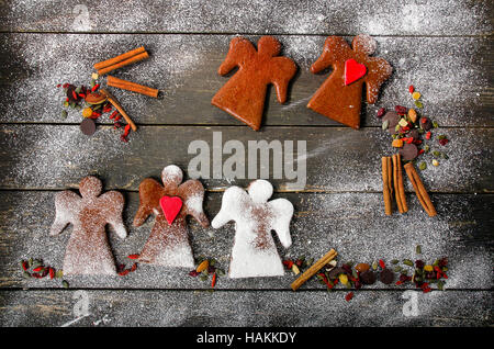Les anges d'épices de Noël avec des épices sur un fond de bois rustique. Mise à plat Banque D'Images