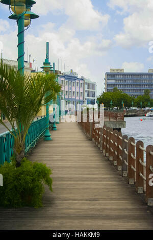 Promenade au bord de la mer avec des bateaux et des bâtiments à Bridgetown Barbade Banque D'Images