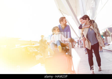 Balades en famille avec chariot à bagages de l'aéroport à l'extérieur Banque D'Images