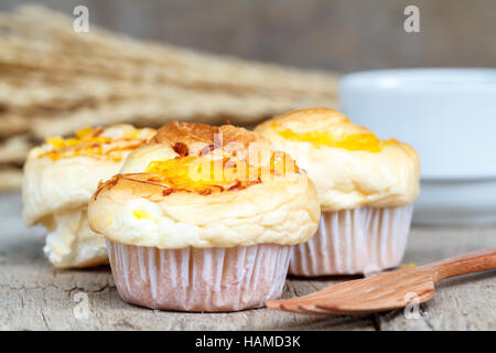 Fils d'or Muffin avec fourche en bois et du café noir sur la table en bois. Dessert thaïlandais appeler Foi Thong. Banque D'Images