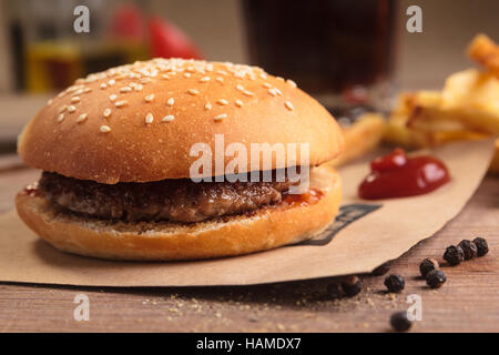 Concept : Les menus de restaurant, d'une saine alimentation, faits maison, gourmands, la gourmandise. Hamburger classique avec des ingrédients, des boissons et des frites sur messy vintage Banque D'Images