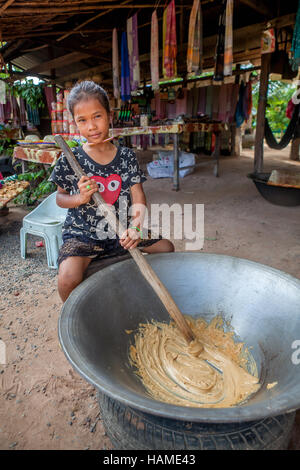 A dix ans, elle prépare Khmer pour la vente de bonbons de sucre de palme pour les touristes sur la route à Banteay Srei, Royaume du Cambodge. Banque D'Images