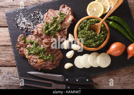 Pavé de boeuf grillé avec sauce aux fines herbes épicées libre sur une liste de sélection. Vue du dessus horizontale Banque D'Images