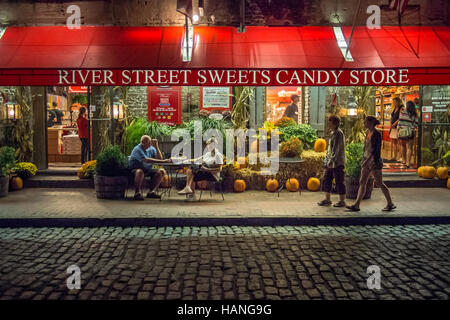 Couple détendez-vous dans la soirée à l'extérieur d'un magasin de bonbons à Savannah Banque D'Images
