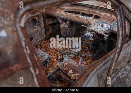 Une voiture incendiée trouvé abandonné par des vandales inconnus le 27 novembre 2016, dans les bois près de Wormshill, Kent, Angleterre. Banque D'Images