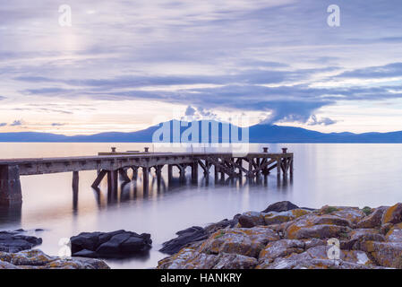 L'ancienne jetée ou Pier à Portencross avec l'Arran Hills dans l'arrière-plan. Banque D'Images