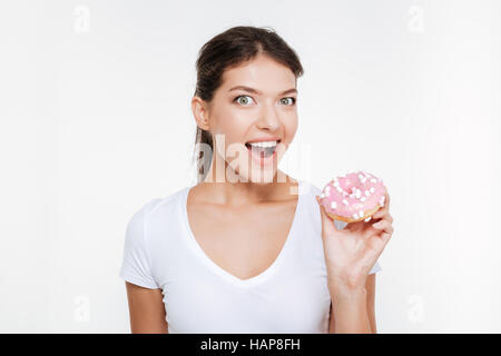 Drôle de photo young woman eating tasty donut isolé sur fond blanc Banque D'Images