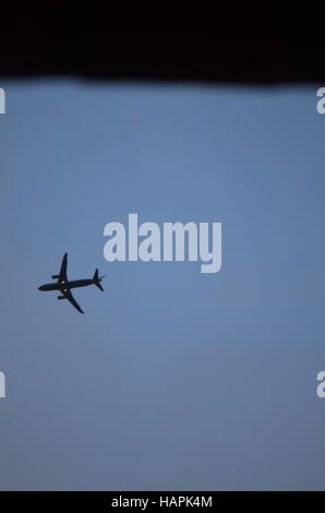 figure d'un avion volant haut dans le ciel bleu Banque D'Images