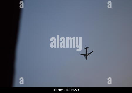 figure d'un avion volant haut dans le ciel bleu Banque D'Images