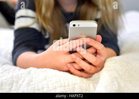 Teen / tween girl holding a mobile phone (iphone) Banque D'Images