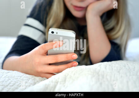 Teen / tween girl holding a mobile phone (iphone) Banque D'Images