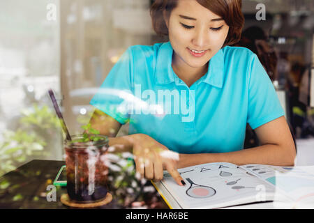 Asian Woman Reading Book Compétences Tennis Concept Banque D'Images