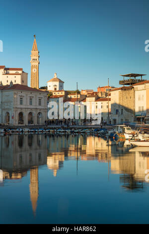 La lumière du soleil du soir sur la Marina, flèche de l'église paroissiale de Saint Georges et du centre-ville (Tartinijev trg), Piran, Slovénie Primorska, Banque D'Images