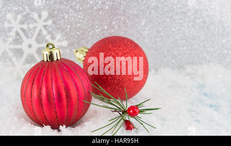 Boules de Noël rouge brillant sur fond argenté Banque D'Images