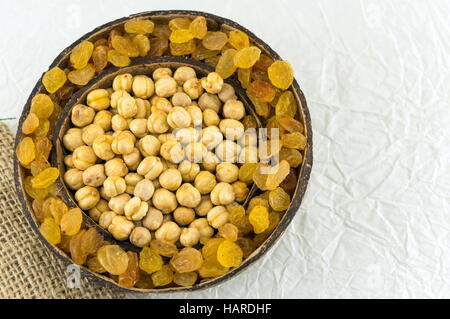 Les pois chiches et les raisins secs dans une grande coque de noix de coco Banque D'Images
