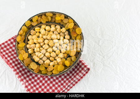 Les pois chiches et les raisins secs dans une grande coque de noix de coco Banque D'Images