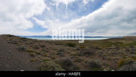 Argentine : un chemin de terre et vue panoramique sur la végétation Patagonique typique avec vue sur le lac Argentino dans le parc national des Glaciers Banque D'Images