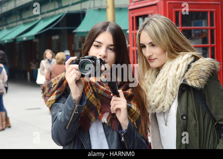 Portrait de deux jeunes touristes de prendre une photo avec appareil photo. Concept du tourisme. À l'extérieur. Banque D'Images