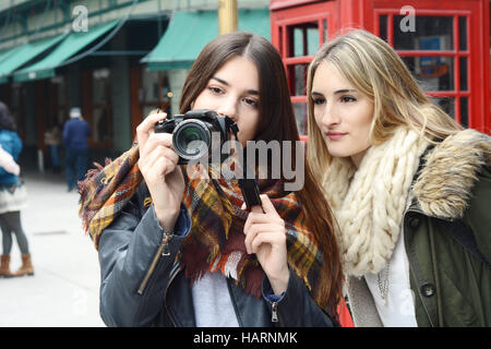 Portrait de deux jeunes touristes de prendre une photo avec appareil photo. Concept du tourisme. À l'extérieur. Banque D'Images