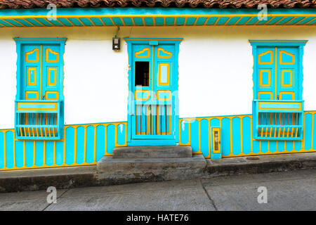 Détail d'une porte en bois et fenêtres peintes de couleurs vives dans une maison coloniale traditionnelle dans la ville de Salento, en Colombie, en Amérique du Sud ; Banque D'Images