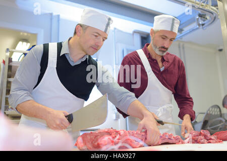 Deux bouchers préparer la viande en boutique Banque D'Images