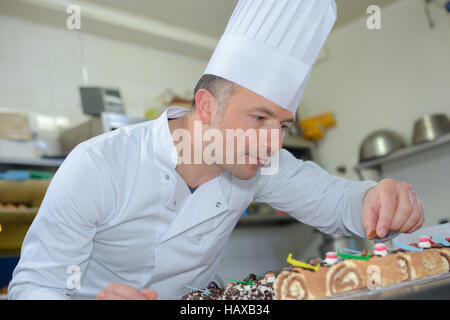 Chef pâtissier holding délicieux gâteaux et pâtisseries Banque D'Images