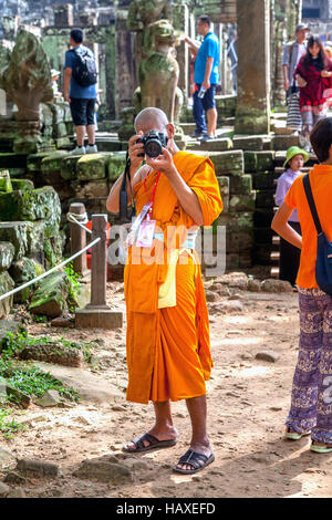 Un moine bouddhiste tournée prend des photos dans l'ancien temple du complexe d'Angkor Thom à Siem Reap, Royaume du Cambodge. Banque D'Images