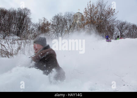 Le traîneau à cheval les jeunes à partir de la pente de neige des chutes de neige au parc de Moscou, Russie Banque D'Images