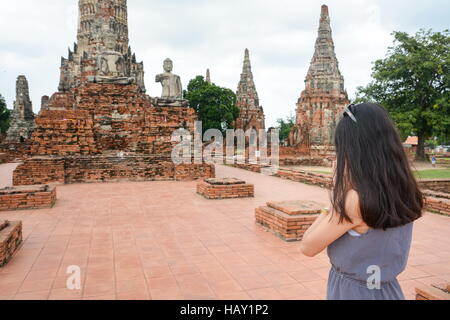 Fille priant devant Bouddha à Ayutthaya, Thaïlande Banque D'Images