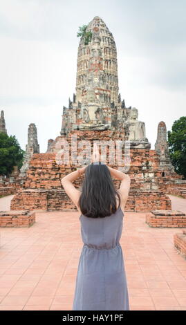 Fille priant devant Bouddha à Ayutthaya, Thaïlande Banque D'Images