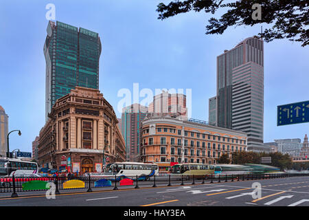 Rue de la ville autour de la place du peuple de Shanghai. Mélange d'architecture coloniale historique et les gratte-ciel modernes derrière les véhicules du trafic trouble. Banque D'Images
