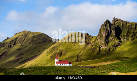 Église blanche avec un toit rouge sur une colline dans la région de Vik, Islande Banque D'Images