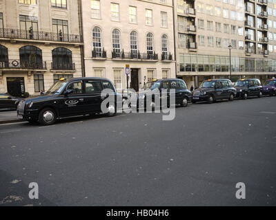 Les taxis noirs de Londres pour des clients d'attente dans une rue du centre de Londres Banque D'Images